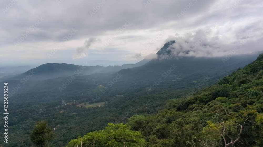 Scenic view of rugged mountains covered in clouds and green forest trees in highlands of central Sri Lanka Scenic view of rugged mountains covered in clouds and green forest trees in highlands of central Sri Lanka