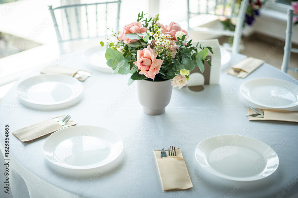 Restaurant table setting with white plate and cutlery