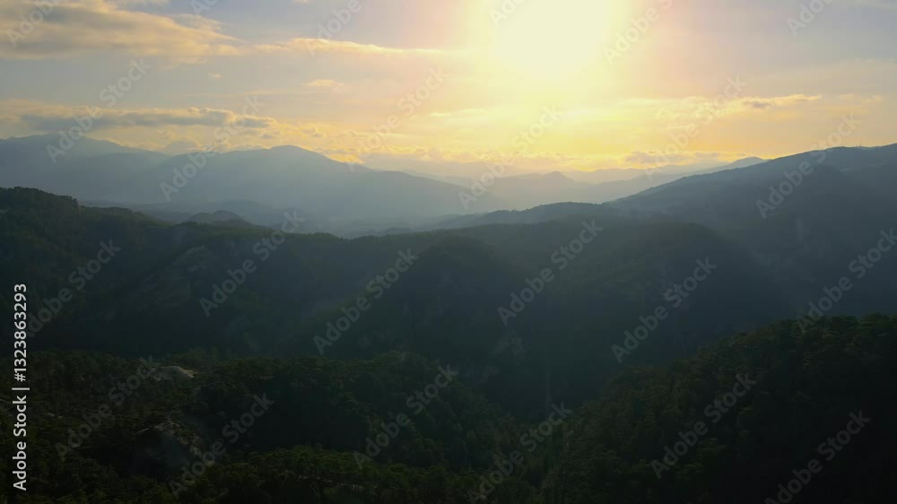Aerial view mountain range with a sun in the sky Aerial view mountain range with a sun in the sky