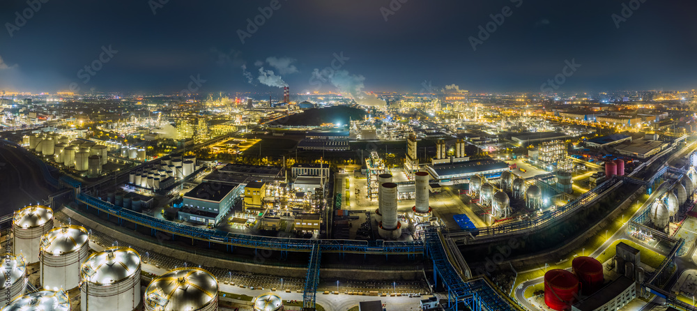 Fototapeta premium Aerial panoramic view of illuminated industrial complex at night