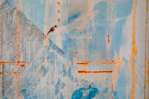 Textures and patterns of rust and peeling paint on the corrugated side of an old shipping container