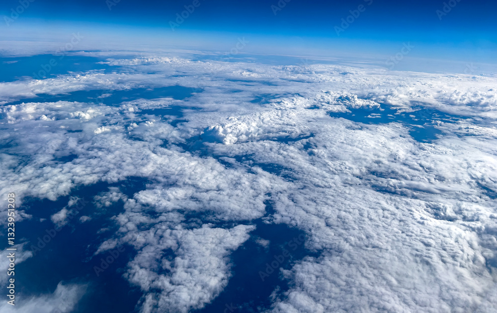 Obraz premium Aerial photography high in the sky above the clouds during the day showing a dark blue sky