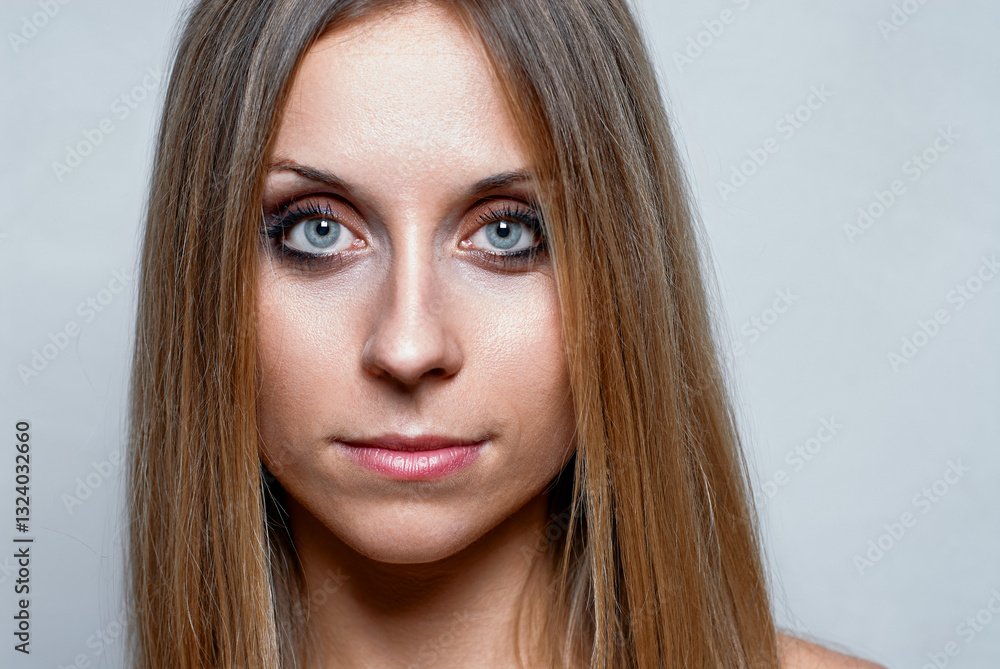 Fototapeta premium Close-Up Portrait of a Woman with Long Hair and Intense Blue Eyes