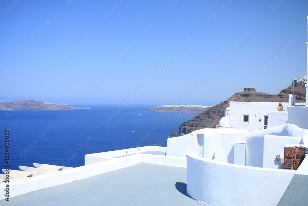 Fototapeta premium Coastline of Santorini with Oia village in the far distance and traditional building in the foreground