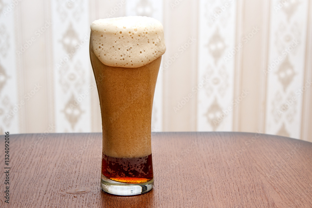 dark beer is poured into a glass