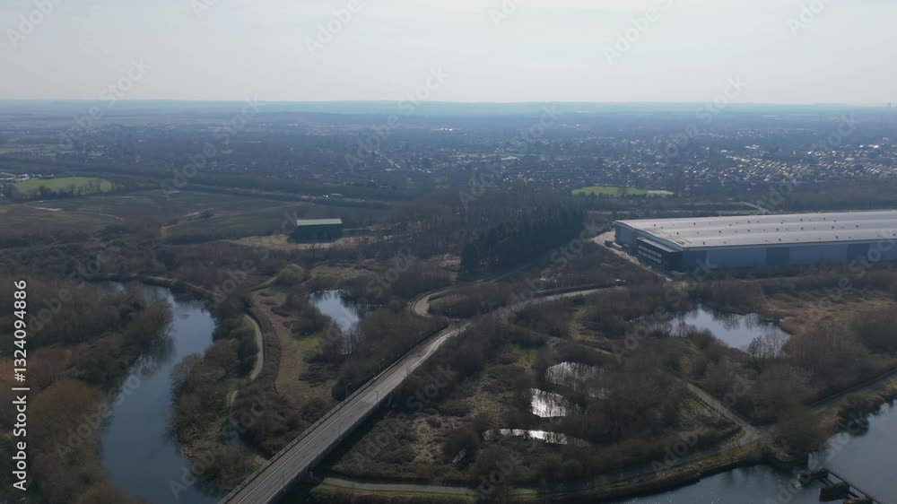 Aerial view of warehouse business district production processes industrial units near town and wetland river area on a sunny winter day in England UK Europe. Aerial view of warehouse business district production processes industrial units near town and wetland river area on a sunny winter day in England UK Europe.