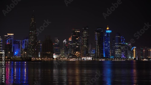 Wallpaper Mural Doha, Qatar - Colorful illuminated skyline of Doha at night with traditional wooden boats called Dhows in the foreground, Qatar, Middle East against dark sky Torontodigital.ca