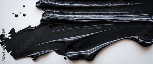 Image of wet dark ink residue, black linocutting paint roller texture set against a white paper backdrop. photo