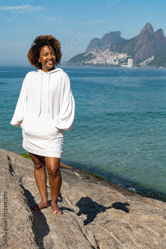Portrait of a confident young woman in white blouse with blue sea view on the background. 