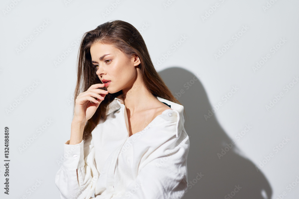 Fashion portrait of a confident young woman with long hair in a white shirt against a light background, showcasing beauty and elegance Soft shadows enhance the aesthetic Fashion portrait of a confident young woman with long hair in a white shirt against a light background, showcasing beauty and elegance Soft shadows enhance the aesthetic