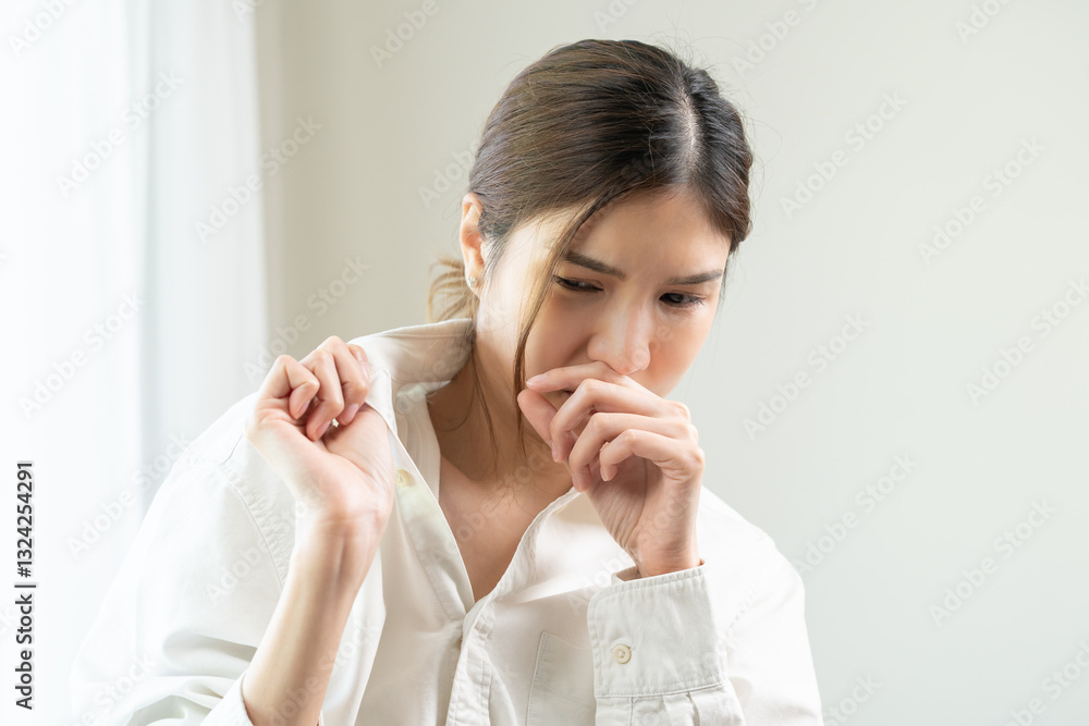 Bad smell nose concept asian young housewife woman having smelling clothes her shirt collar, sniff smelly dirty stinky musty, look disgusting from clothes after washed, laundry out of machine at home. Bad smell nose concept asian young housewife woman having smelling clothes her shirt collar, sniff smelly dirty stinky musty, look disgusting from clothes after washed, laundry out of machine at home.