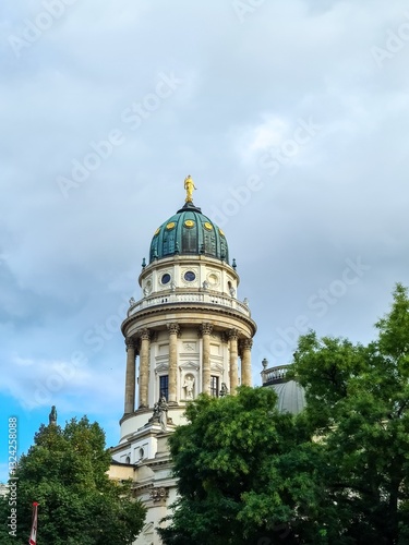 Deutscher Dom in Berlin with trees and cloudy sky