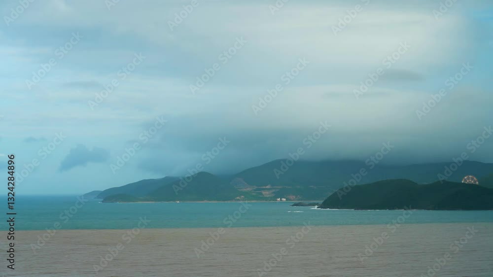 Lenticular clouds cling to mountains on an island at sea in windy stormy weather, cloudscape time lapse. Summer shift gray sky time lapse loop Lenticular clouds cling to mountains on an island at sea in windy stormy weather, cloudscape time lapse. Summer shift gray sky time lapse loop