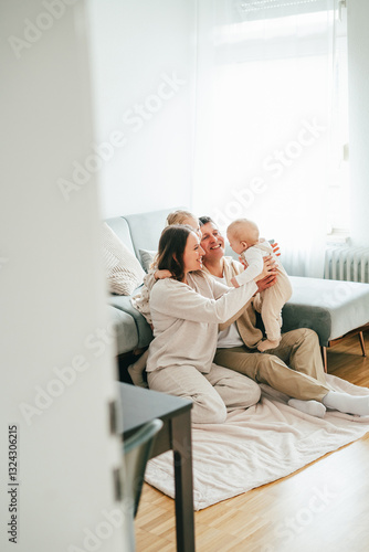 Beautiful happy young family with small children resting at home.