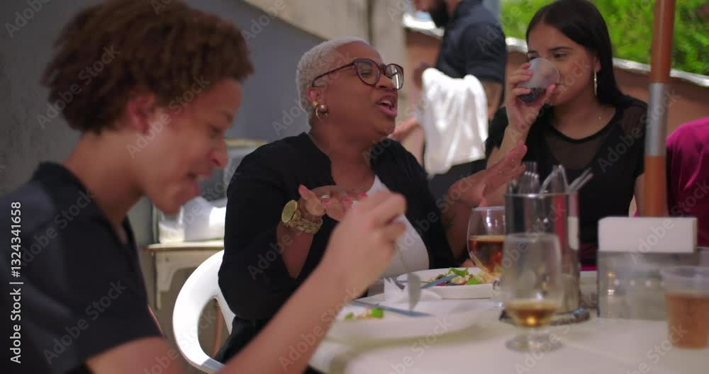 Family and friends enjoying laughter and food at a backyard lunch, cheerful and casual atmosphere with bonding moments around a table