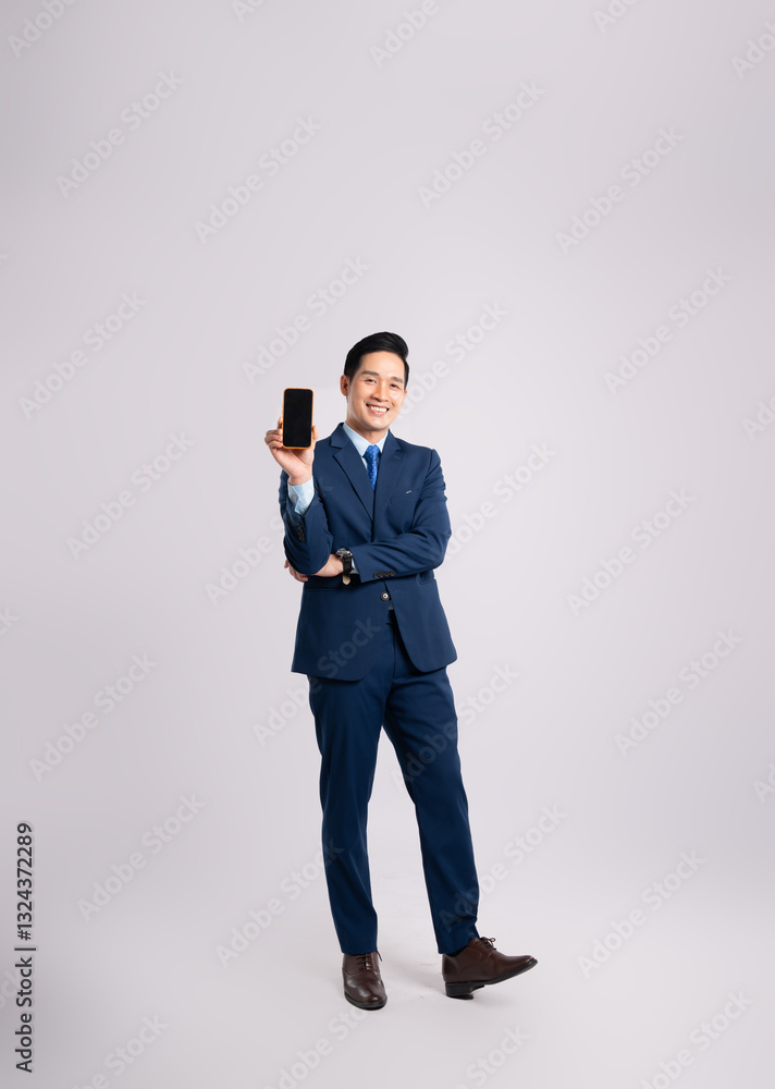 Full body image of Asian male businessman wearing a suit using phone and posing on a white background Full body image of Asian male businessman wearing a suit using phone and posing on a white background