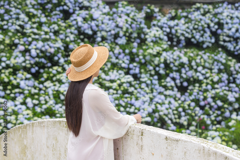 Expecting mother relaxing in blooming flower field