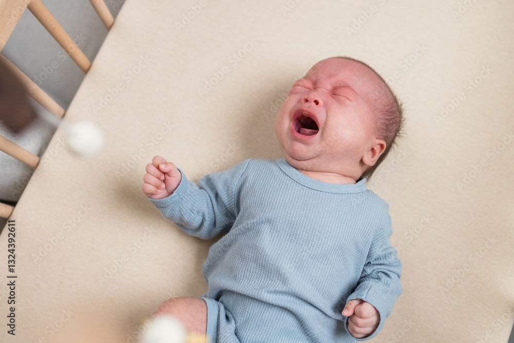 Tired newborn crying in cozy nursery