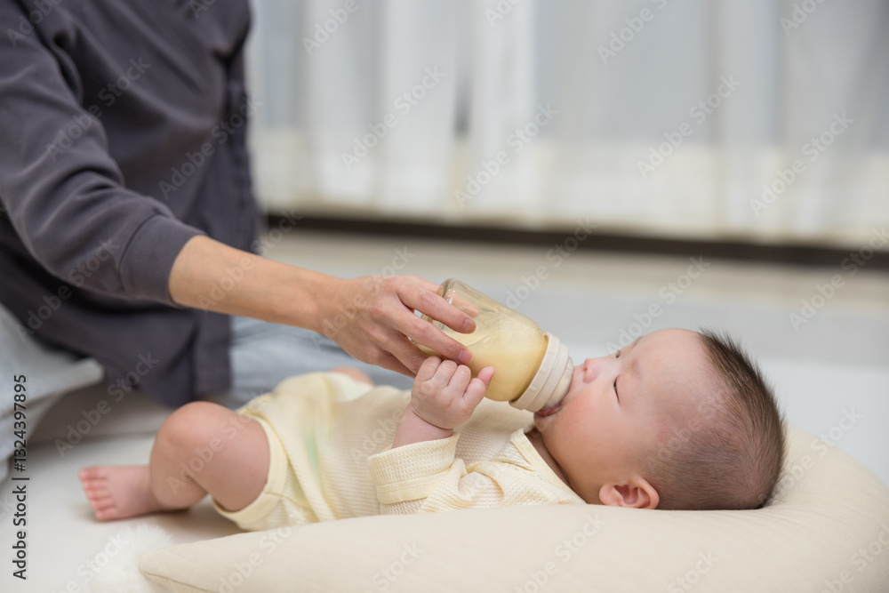 Baby drinking milk while lying indoors