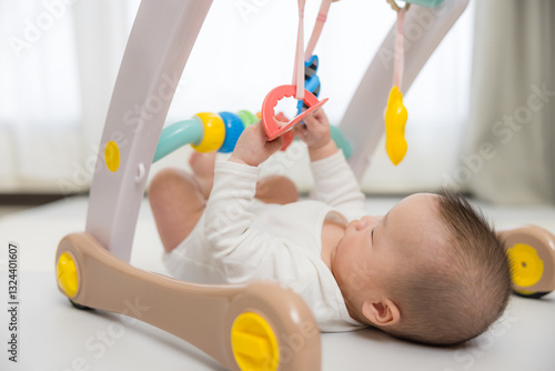 Obraz na płótnie Baby playing with hanging toy on play gym w salonie