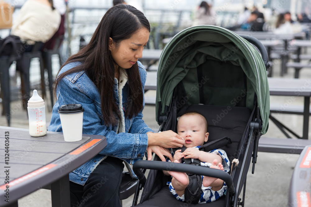 Mother taking care baby in stroller outdoor