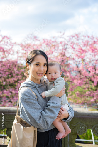 Obraz na płótnie Young mother and baby enjoying cherry blossoms together w salonie