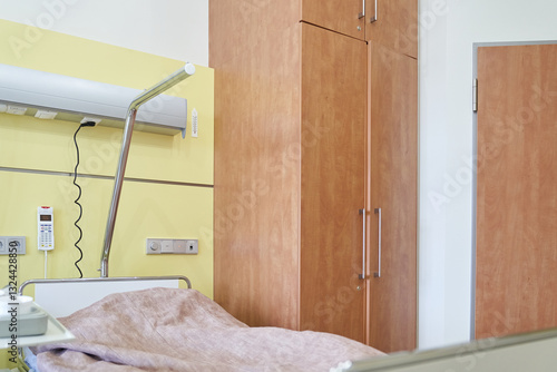 There is an inpatient bed in the postoperative ward against the background of the closet. Modern adjustable bed for hospital patients. With space to copy. High quality photo photo