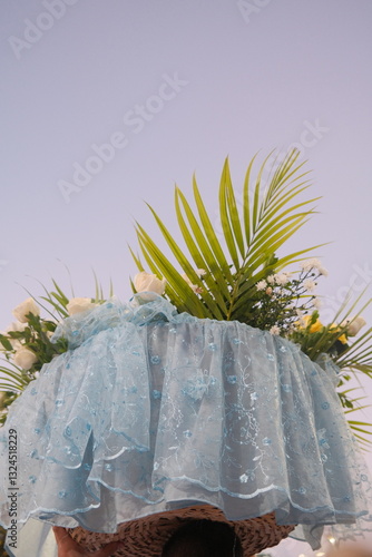 Wallpaper Mural A floral offering for Iemanjá held up against a soft pastel sunrise sky at Praia Vermelha, Salvador, Bahia, during the Dia de Iemanjá celebration. Torontodigital.ca