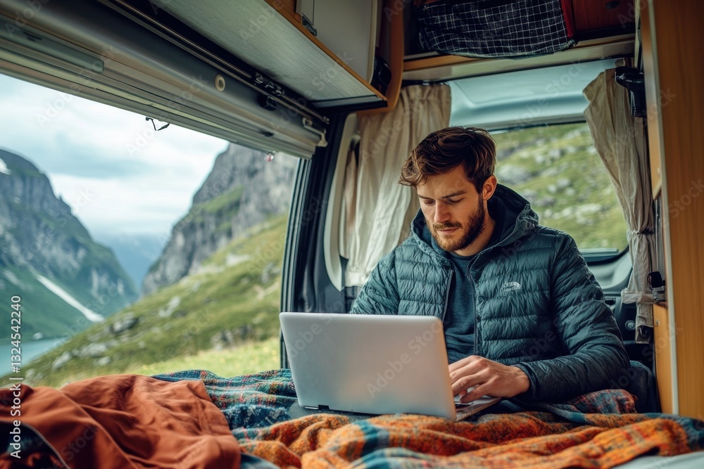 Freelancer working remotely on laptop in camper van with mountain view