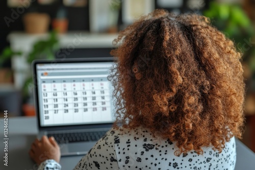 a person looking at a calendar on a laptop.