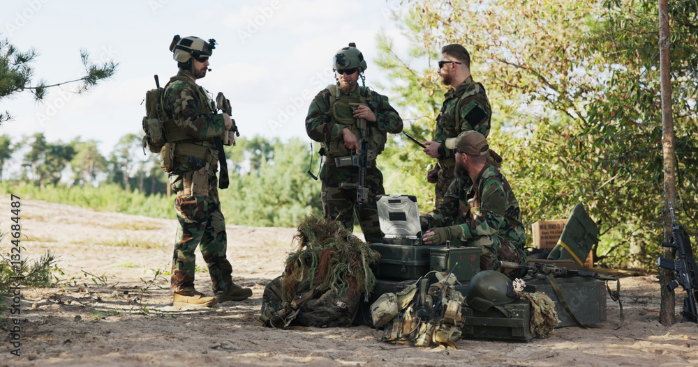 A military unit finalizes mission details, preparing for a forest expedition by analyzing maps, entering data on the computer, sending updates to base, and securing gear. A military unit finalizes mission details, preparing for a forest expedition by analyzing maps, entering data on the computer, sending updates to base, and securing gear.
