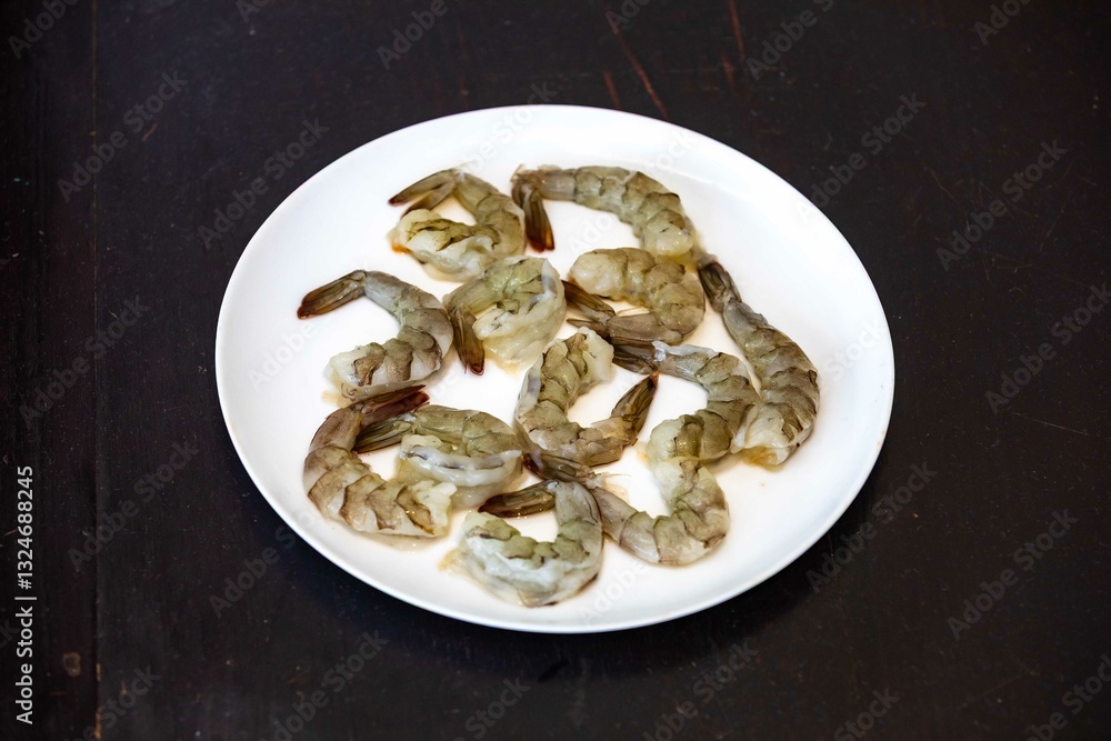 Fresh shrimps on white round plate isolated in selective focus. Shrimp head Fresh shrimps on white round plate isolated in selective focus. Shrimp head