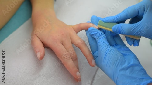 A manicurist performing a Japanese manicure on a client
