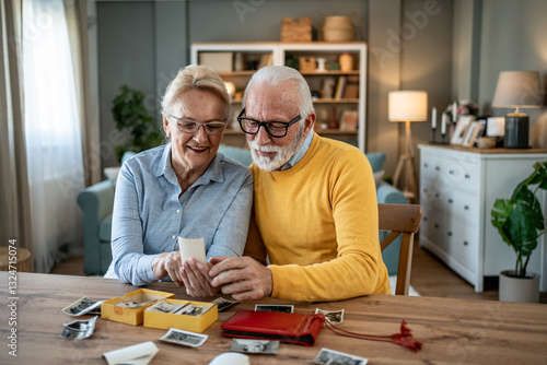 Принти на полотні Senior couple watching old photos at home, remembering past times