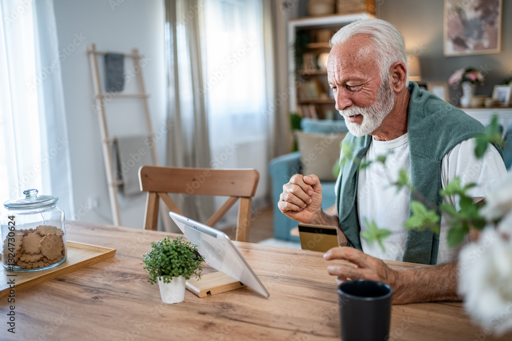 Senior man using tablet and credit card for online shopping at home Senior man using tablet and credit card for online shopping at home
