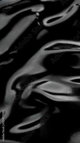 Mesmerizing black liquid waves create hypnotic abstract movement in elegant flowing pattern