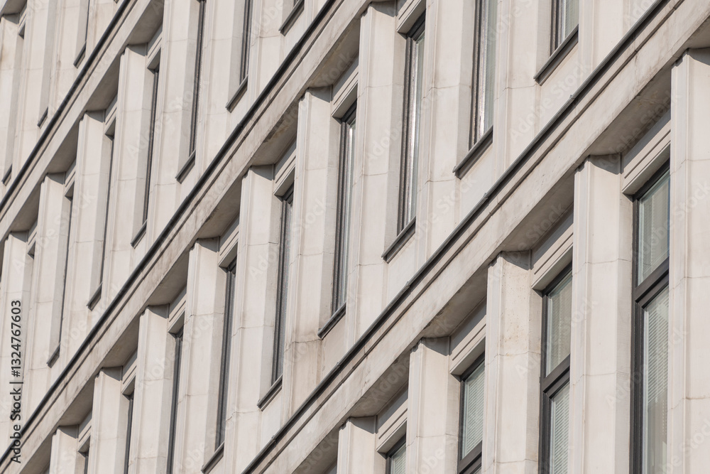 A modernist facade with repeating vertical concrete elements, creating rhythmic patterns and dynamic diagonal shadows. A modernist facade with repeating vertical concrete elements, creating rhythmic patterns and dynamic diagonal shadows.
