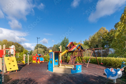 Wallpaper Mural A playground with many game elements, surrounded by lush greenery against a blue sky on a sunny autumn day. Torontodigital.ca
