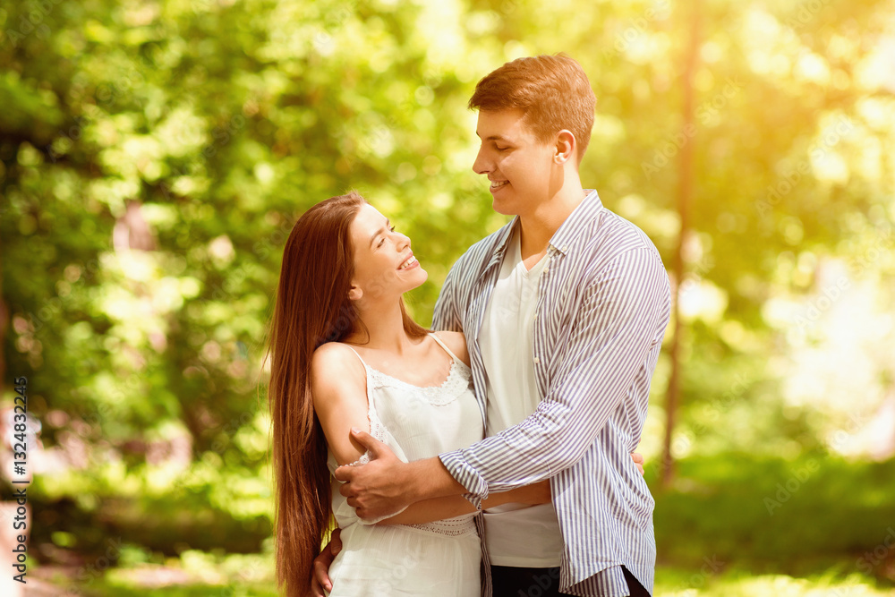 Beautiful loving couple hugging and looking at each other in summer park Beautiful loving couple hugging and looking at each other in summer park