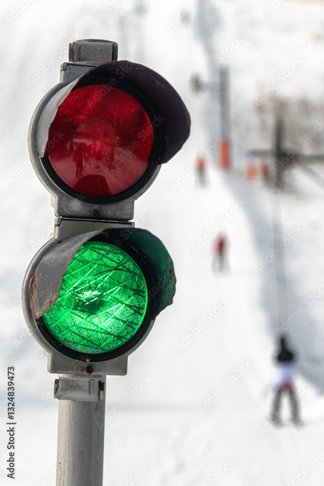 Green light on traffic light on slope with ski lift. Start of winter season