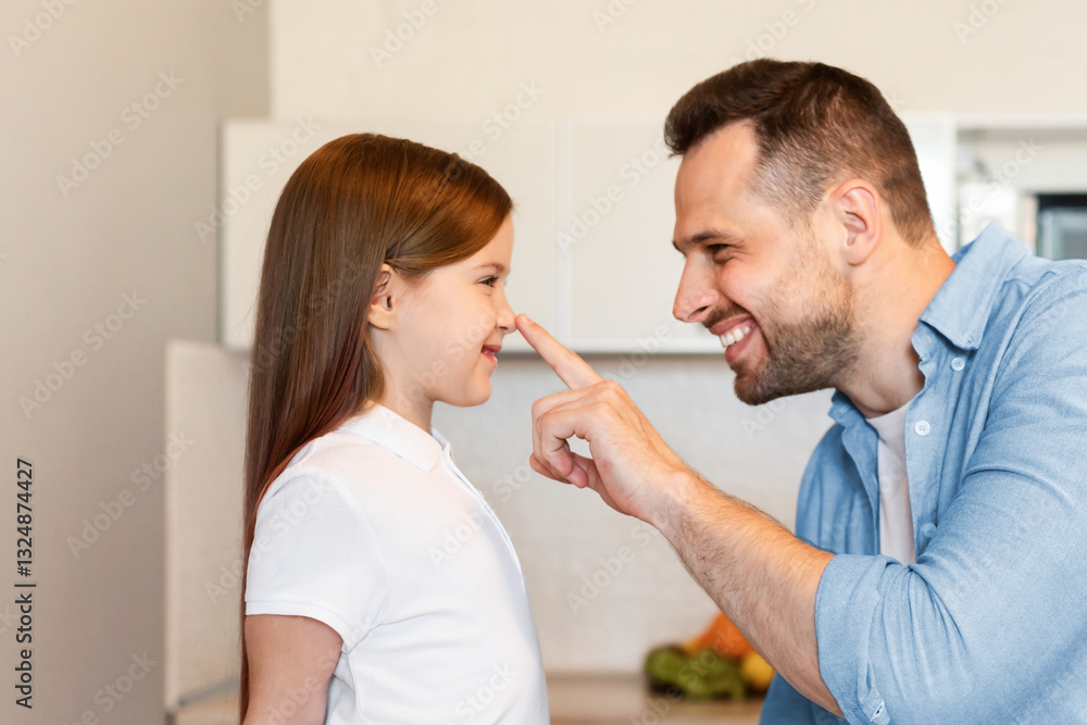 Father's Love. Cheerful Dad Touching Little Daughter's Nose Playfully Feeling Proud Of His Beautiful Adorable Child Posing In Modern Kitchen At Home, Side View. Happy Fatherhood Moments Concept Father's Love. Cheerful Dad Touching Little Daughter's Nose Playfully Feeling Proud Of His Beautiful Adorable Child Posing In Modern Kitchen At Home, Side View. Happy Fatherhood Moments Concept