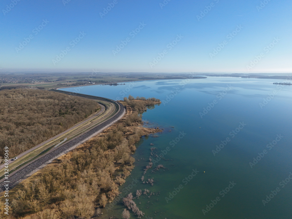 Lac d'orient and its vegetation in winter, reservoir lake on the Seine in the Aube département in France, in the nature reserve of the forêt d'orient in Champagne with a road beside it Lac d'orient and its vegetation in winter, reservoir lake on the Seine in the Aube département in France, in the nature reserve of the forêt d'orient in Champagne with a road beside it