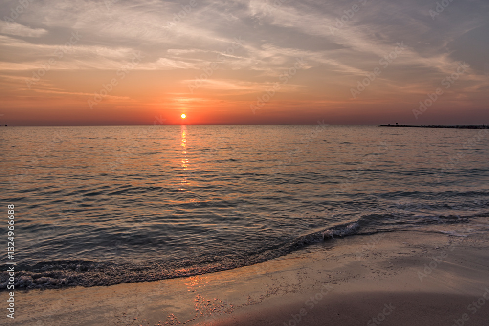 Il mare al tramonto e cielo leggermente nuvoloso Il mare al tramonto e cielo leggermente nuvoloso