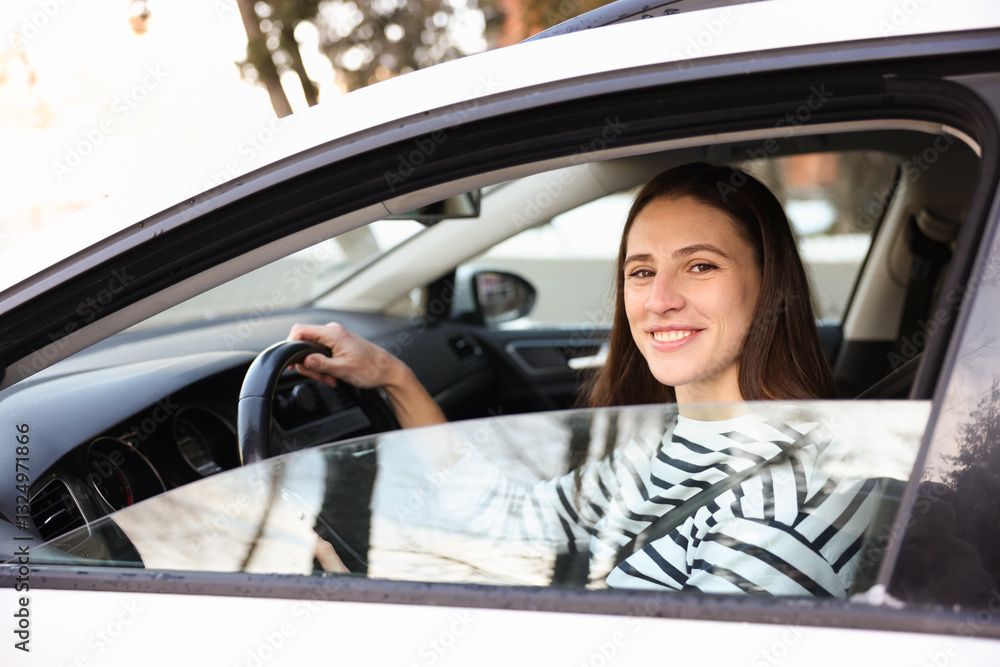 Driver behind steering wheel of modern car, view from outside Driver behind steering wheel of modern car, view from outside