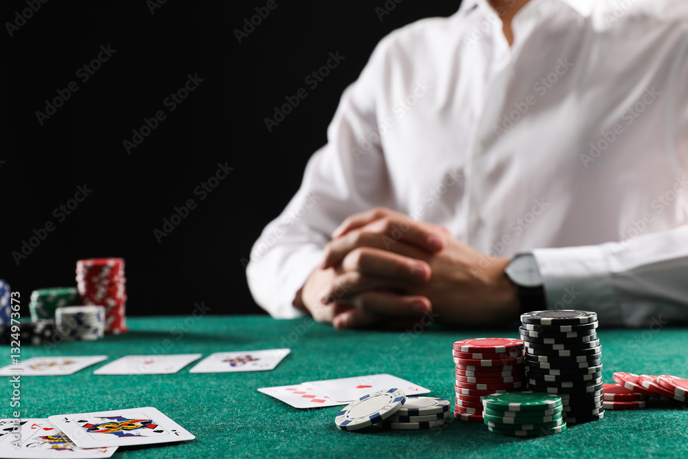 Man with cards and casino chips playing poker at gambling table, closeup Man with cards and casino chips playing poker at gambling table, closeup