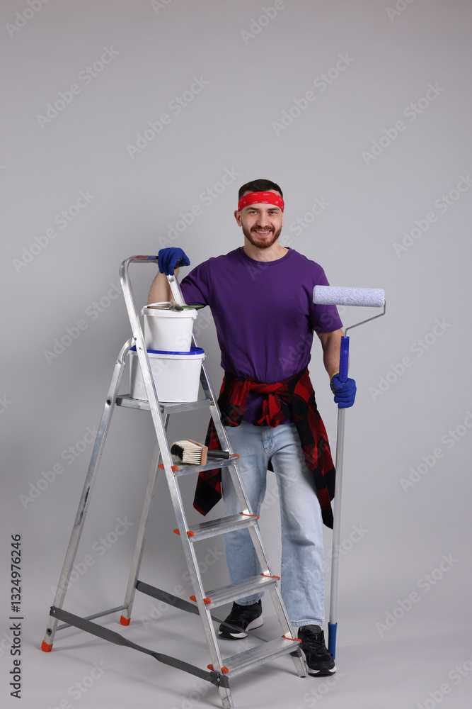 Man with tools and supplies on light grey background Man with tools and supplies on light grey background