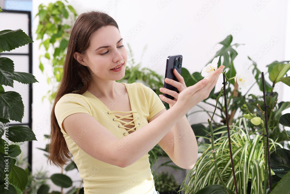 Woman using houseplant recognition application on smartphone indoors Woman using houseplant recognition application on smartphone indoors