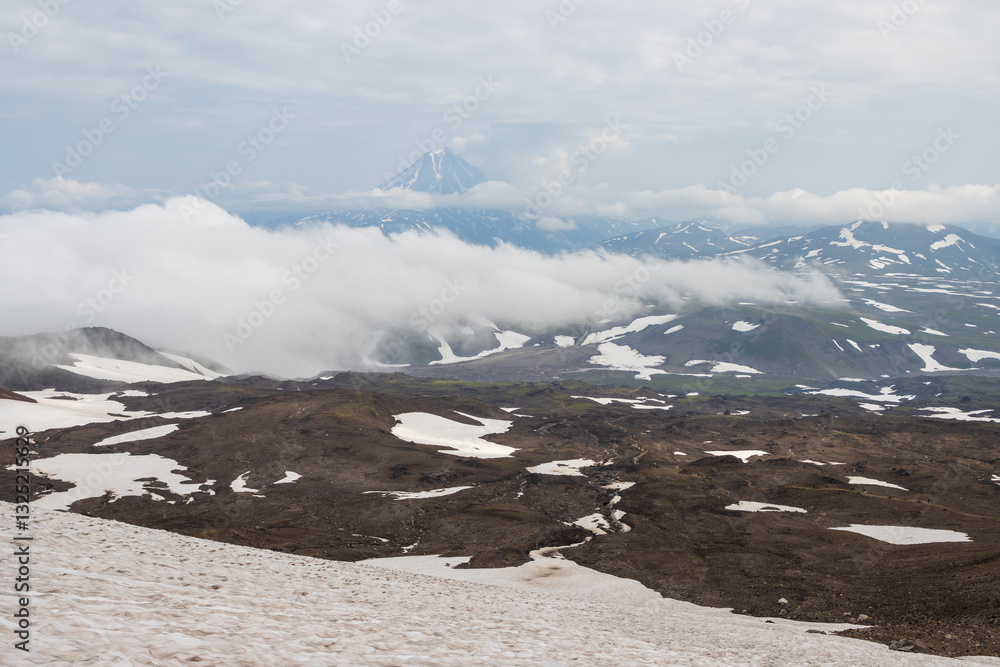 View from Gorely volcano to Vilyuchinsky volcano, Kamchatka Territory, Russia. Mountain landscape. Travel, tourism and hiking on the Kamchatka Peninsula. Beautiful nature of the Russian Far East.