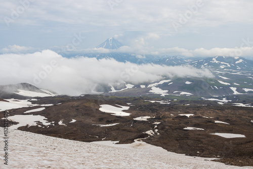 Obraz na płótnie View from Gorely volcano to Vilyuchinsky volcano, Kamchatka Territory, Russia. Mountain landscape. Travel, tourism and hiking on the Kamchatka Peninsula. Beautiful nature of the Russian Far East. w salonie