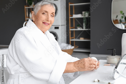 Senior woman with jar of cr...